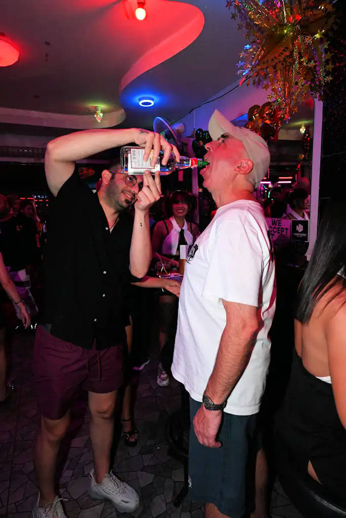 Manager Sam pouring alcohol contents down customer's throat